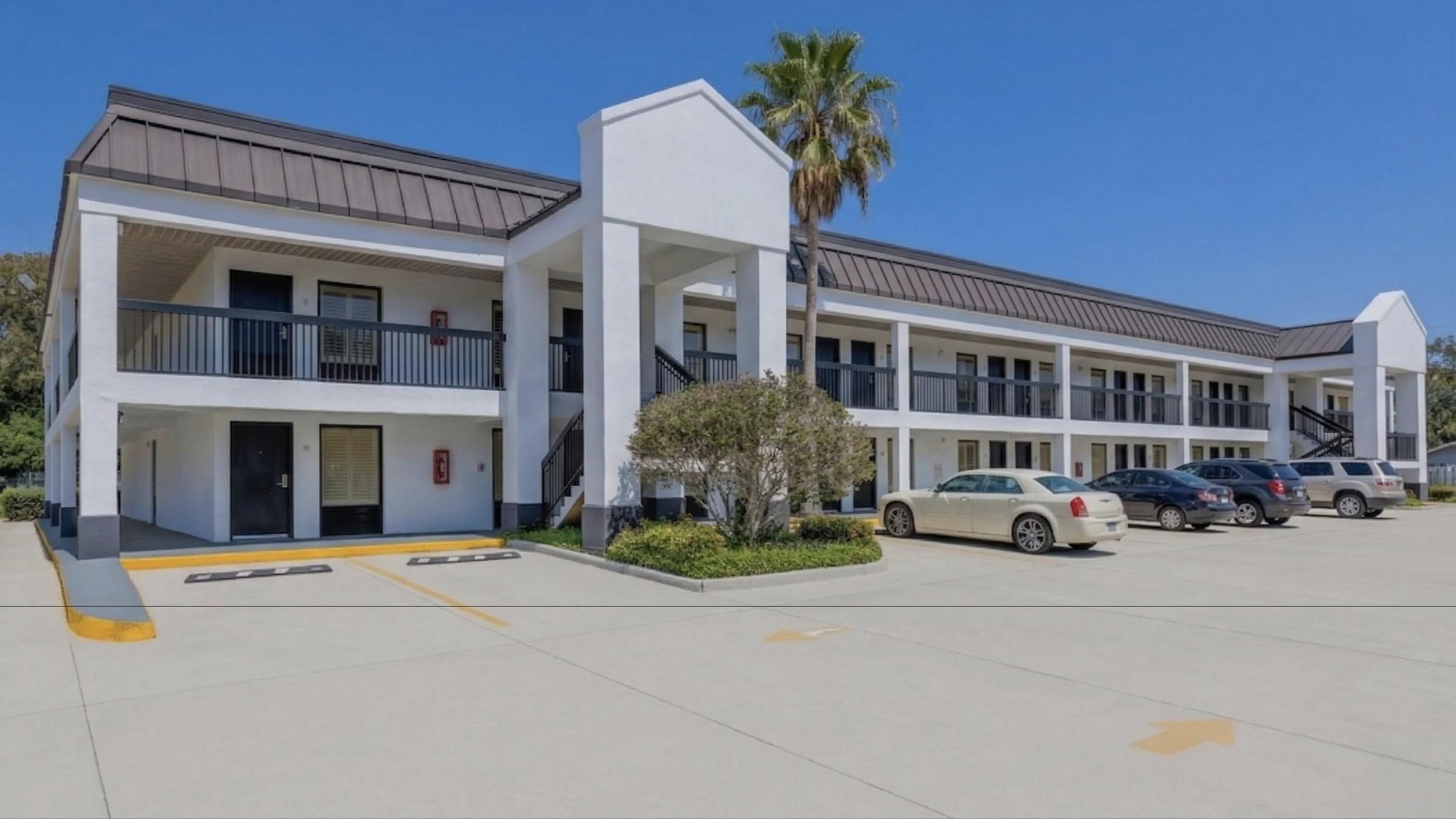 The Gulf House, a two-story hotel with a palm tree out front